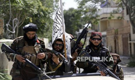 FILE - In this Aug. 19, 2021 file photo, Taliban fighters display their flag on patrol in Kabul, Afghanistan.  Twin tragedies on opposite sides of the world are piling misery on people that have seen far more than their share. In Afghanistan, a group of gunmen known for sadistic tyranny rocketed back into power after 20 years as Western and Afghan leaders walked away with a sad shrug.  