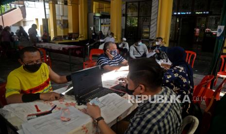 Petugas memberikan kartu vaksin kepada warga usai mengikuti vaksinasi Covid-19 di halaman Masjid Al Muhajirin, Kelapa Gading, Jakarta, Ahad (8/8). Pemprov DKI Jakarta dan Dewan Masjid Indonesia Provinsi DKI Jakarta berkolaborasi menggelar vaksinasi di Masjid bagi para pengurus, jamaah, maupun warga yang berada di sekitar masjid dalam rangka mendukung program percepatan vaksinasi covid-19 pemerintah. Prayogi/Republika.