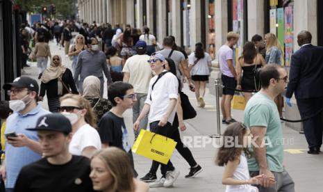 Sejumlah warga berjalan membawa tas usai berbelanja di department store Selfridges, London, Senin, (15/6). Setelah tiga bulan ditutup karena lockdown akibat wabah virus Corona, toko-toko yang menjual pakaian, mainan, dan barang-barang lainnya diizinkan untuk dibuka kembali di Inggris untuk pertama kali sejak negara itu memberlakukan lockdown pada bulan Maret