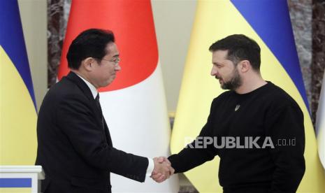  Perdana Menteri Jepang Fumio Kishida (kiri) dan Presiden Ukraina Volodymyr Zelensky (kanan) berjabat tangan selama konferensi pers bersama setelah pertemuan mereka di Kyiv, Ukraina, Selasa (21/3/2023). Fumio Kishida tiba di Kyiv untuk bertemu dengan pejabat tinggi Ukraina di tengah invasi Rusia yang sedang berlangsung .