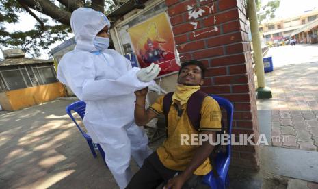  Seorang pelancong bereaksi ketika seorang petugas kesehatan mencoba mengambil usap hidungnya untuk tes COVID-19 di luar stasiun bus di Bengaluru, India, Rabu, 17 Februari 2021. Sekelompok lebih dari 100 kasus telah terdeteksi di kota selatan India Bengaluru di sebuah kompleks apartemen, yang mendorong otoritas negara untuk mewajibkan pengujian RT-PCR bagi pelancong internasional, atau mereka yang pernah mengunjungi atau transit baik melalui Afrika Selatan atau Brasil.