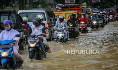 Sejumlah pengendara melintasi banjir di kawasan Tigaraksa, Kabupaten Tangerang, Banten, Rabu (20/5/2020). Genangan air tersebut di jalan tersebut terjadi akibat luapan sungai Cimanceuri