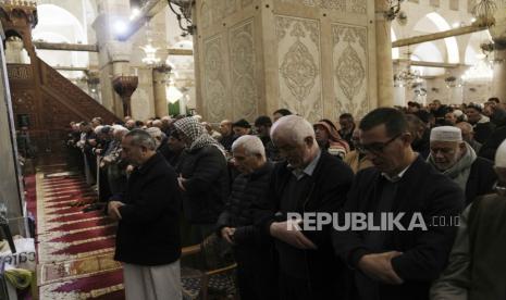 Muslim Palestina sholat berjamaah  pada bulan suci Ramadhan di kompleks Masjid Al-Aqsa menyusul penggerebekan oleh polisi Israel di Kota Tua Yerusalem,  Rabu (5/4/2023) 