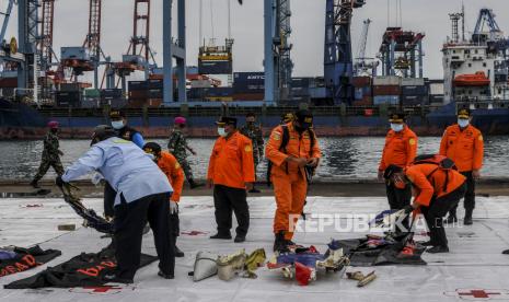 Petugas memeriksa serpihan bagian pesawat Sriwijaya Air SJ182 rute Jakarta - Pontianak yang jatuh di perairan Pulau Seribu di Dermaga JICT, Tanjung Priok, Jakarta Utara, Ahad (10/1). Serpihan pesawat Sriwijaya Air SJ182 itu diserahkan kepada KNKT untuk diteliti lebih lanjut. Republika/Putra M. Akbar