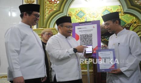 Direktur Utama PT Bank Muamalat Indonesia Tbk Indra Falatehan (kiri), Direktur Operasi dan Digital Wahyu Avianto (kedua kiri) mejelaskan fitur sedekah melaui QRIS saat Gerakan Bersih Masjid yang dilaksanakan di Masjid Jami Baitur Rahmah, Jakarta, Sabtu (7/10/2023). Kegiatan ini adalah implementasi dari tanggung jawab sosial perusahaan kepada masyarakat khususnya yang berdomisili di lingkungan sekitar kantor Bank Muamalat beroperasi. Selain itu, gerakan ini adalah bentuk perhatian Bank Muamalat terhadap pentingnya kebersihan dan kenyamanan rumah ibadah.