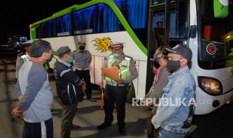 Polisi meminta keterangan dari sopir dan penumpang bus yang akan mudik saat operasi pengamanan dan penyekatan wabah COVID-19 di Badung, Bali, Minggu (3/5/2020). Bus yang membawa sekitar 39 penumpang menuju Sidoarjo, Jawa Timur itu digiring untuk menjalani pemeriksaan di Polres Badung karena surat izin jalan bermasalah dan diduga mengambil penumpang di luar terminal