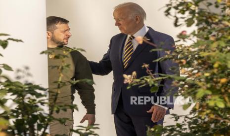  Presiden AS Joe Biden (kanan) dan Presiden Ukraina Volodymyr Zelensky (kiri) berjalan menyusuri barisan tiang sebelum bertemu di Oval Office Gedung Putih, di Washington DC, AS, 21 Desember 2022. Zelenskiy melakukan perjalanan luar negeri pertamanya sejak Rusia menginvasi Ukraina lebih dari 300 hari yang lalu, melakukan perjalanan ke AS dalam kunjungan berisiko tinggi untuk mendapatkan dukungan untuk upaya perangnya.