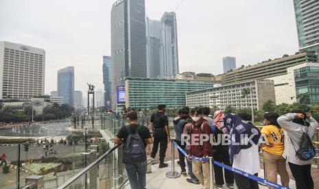 Sejumlah warga berfoto di anjungan Halte Transjakarta Bundaran HI saat uji coba anjungan itu di kawasan Bundaran Hotel Indonesia, Jakarta, Ahad (9/10/2022). Anjungan yang berada di lantai dua Halte Transjakarta Bundaran HI ini dapat menampung 20 orang dan menjadi spot foto baru dengan latar belakang Patung Selamat Datang dan air mancur Bundaran HI. 