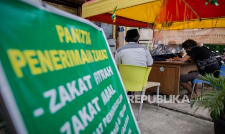 Petugas menggunakan masker saat melayani warga menunaikan pembayaran zakat fitrah di Masjid Nurul Huda, Kebagusan, Jakarta, Rabu (20/5). ilustrasi