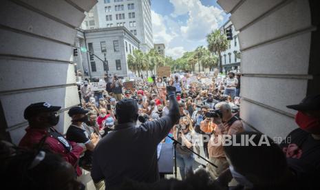 Seorang pembicara berpidato di hadapan para pengunjuk rasa di tangga City Hall selama rapat umum hari Minggu, 31 Mei 2020, di Savannah, Ga., Mengenai kematian George Floyd dan yang lainnya. Floyd meninggal pada 25 Mei setelah ia dijepit di leher oleh seorang petugas kepolisian Minneapolis.