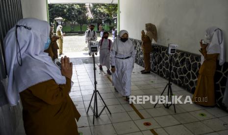 Sejumlah pelajar memberi salam kepada guru usai mengikuti pembelajaran tatap muka (PTM) 100 persen di SDN 065 Cihampelas, Jalan Cihampelas, Kota Bandung, Senin (10/1). Pemerintah Kota Bandung melalui Dinas Pendidikan Kota Bandung mulai menggelar PTM dengan kapasitas 100 persen di 330 sekolah berbagai jenjang mulai Senin (10/1). Foto: Republika/Abdan Syakura