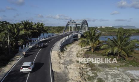 Foto udara kendaraan melintasi Jembatan Wiradinata Rangga Jipang di Kabupaten Pangandaran, Jawa Barat, Senin (17/7/2023). Pemerintah Povinsi Jawa Barat telah memperbaiki dan membangun jalan baru atau jalan lintas pantai sepanjang 1.150 kilometer yang menghubungkan Pantai Pangandaran dengan Pantai Madasari, untuk menunjang sektor pariwisata. 