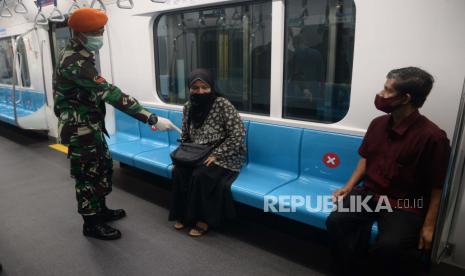 Personil TNI menghimbau penumpang untuk menerapkan jaga jarak di dalam rangkaian MRT, Bundaraan HI, Jakarta, Selasa (26/5). Kedepannya aparat gabungan TNI dan Polri akan dikerahkan ke berbagai lokasi keramaian untuk mengawasi aktivitas masyarakat dalam penerapan new normal di tengah pandemi covid-19