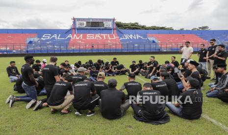 Para pemain dan ofisial Arema FC berkumpul di lapangan untuk menyampaikan belasungkawa kepada para korban kerusuhan di Stadion Kanjuruhan di Malang, Jawa Timur, Indonesia, 3 Oktober 2022. Psikolog dan sosilog mengingatkan pentingnya mengajarkan sportivitas dan rivalitas sehat sejak masih kecil.