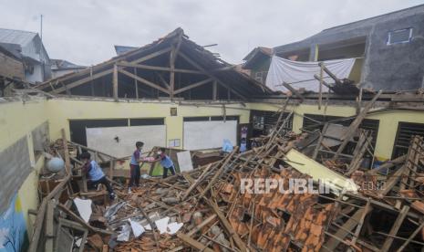 Pelajar menyelamatkan buku di ruangan kelas yang ambruk di SD Negeri Ciheuleut 1, Kota Bogor, Jawa Barat, Selasa (29/3/2022). Sebanyak dua ruangan kelas di sekolah tersebut hancur tertimpa material atap bangunan karena kondisi konstruksi rangka yang sudah keropos dan cuaca yang deras disertai angin kencang. Republika/Putra M. Akbar