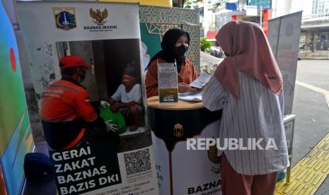 Petugas memberikan informasi terkait zakat kepada warga di Gerai Zakat Baznas (Bazis) DKI Jakarta di Terowongan Kendal, Jakarta, Selasa (19/4/2022). Baznas (Bazis) Provinsi DKI Jakarta menghadirkan layanan Gerai Zakat & Jemput Zakat di beberapa titik hal ini dalam rangka mempermudah warga dalam menunaikan zakat, infak, dan sedekah secara offline selama Ramadhan.Prayogi/Republika.