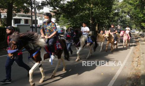  Dinas Kebudayaan dan Pariwisata (Disbudpar) Kota Bandung meminta pelaku usaha wisata di Kota Bandung untuk mematuhi aturan tentang persyaratan pengunjung yang masuk ke objek wisata sudah divaksin booster. Kebijakan itu diharapkan dapat meningkatkan cakupan vaksinasi booster dan mencegah penyebaran Covid-19.  Sejumlah anak menunggang kuda sewa berkeliling taman di kawasan Taman Lansia, Jalan Cisangkuy, Kota Bandung,