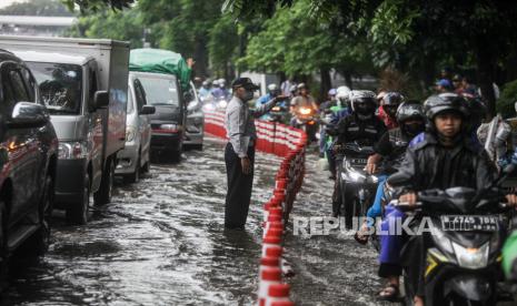 Petugas Dishub DKI Jakarta mengatur lalu lintas saat terjadi genangan air di Jalan DI Pandjaitan, Jatinegara, Jakarta Timur, Senin (5/2/2024). Hujan deras yang mengguyur Jakarta membuat dua ruas Jalan DI Pandjaitan yang berada di Kecamatan Makasar dan Jatinegara tergenang air sehingga mengakibatkan kemacetan..