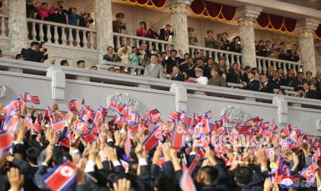 Sebuah foto yang dirilis oleh Kantor Berita Pusat Korea Utara (KCNA) resmi menunjukkan pemimpin Korea Utara Kim Jong-un (tengah) melihat kerumunan yang bersorak-sorai selama parade militer di Lapangan Kim Il-sung di Pyongyang, Korea Utara, awal 09 September 2021 Parade larut malam diadakan di Lapangan Kim Il Sung untuk merayakan ulang tahun ke-73 berdirinya Republik Rakyat Demokratik Korea. Kim Jong-un melarang warga Korut tertawa untuk peringati 10 tahun kematian ayahnya.