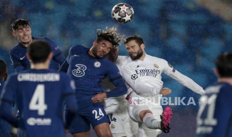 Bek Chelsea Reece James berebut menyundul bola dengan bek Real Madrid Nacho pada pertandingan leg pertama semifinal Liga Champions di stadion Alfredo di Stefano, Madrid, Spanyol, Selasa (27/4) Pertandingan tersebut berakhir dengan skor imbang 1-1, melalui tendangan Karim Benzema dari Real Madrid dan Christian Pulisic dari Chelsea. (AP Photo/Bernat Armangue)