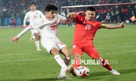 Pesepak bola Timnas Indonesia Victor Dethan (kiri) berebut bola dengan pesepak bola Timnas Vietnam Nguyen Quang Hai (kanan) dalam pertandingan pada laga fase grup Piala AFF 2024 di Stadion Viet Tri, Phu Tho, Vietnam, Ahad (15/12/2024). Indonesia kalah dengan skor 0-1. 