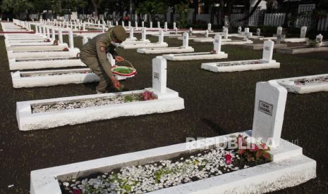 Petugas Satpol PP menabur bunga saat ziarah di Taman Makam Pahlawan (TMP) Kusuma Bangsa, Surabaya, Jawa Timur, Rabu (9/11/2022). Ziarah serta tabur bunga itu dalam rangka peringatan Hari Pahlawan. 