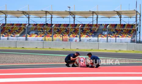 Petugas memasang papan informasi penunjuk kecepatan maksimal di jalur menuju area pit lane Pertamina Mandalika International Street Circuit, di Lombok Tengah, NTB, Kamis (17/3/2022). Ajang balapan MotoGP seri kedua 2022 bertajuk Pertamina Grand Prix of Indonesia akan berlangsung pada 18-20 Maret 2022. 