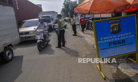 Sejumlah petugas kepolisian mengatur lalu lintas di Check point PSBB (Pembatasan Sosial Berskala Besar), Bekasi, Jawa Barat, Selasa (28/4/2020). Gubernur Jawa Barat Ridwan Kamil memperpanjang masa pemberlakuan PSBB selama 14 hari yang dimulai tanggal (29/4/2020) untuk mencegah penyebaran virus COVID-19 di wiilayah Bodebek (Bogor, Depok dan Bekasi)