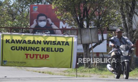 Warga melintas melalui pintu gerbang kawasan wisata gunung Kelud yang ditutup di Desa Sugihwaras, Kediri, Jawa Timur, Selasa (6/7/2021). Pemerintah daerah setempat menutup kawasan wisata gunung Kelud saat penerapan Pemberlakuan Pembatasan Kegiatan Masyarakat (PPKM) Darurat guna mengendalikan penyebaran COVID-19. 