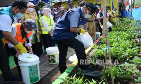 Wali Kota Bandung Oded M Danial (bertopi)memasukan limbah organik ke penampungan untuk dijadikan pupuk organik saat meninjau kawasan Pengelolaan Sampah Mandiri di RW 8, Kelurahan Sarijadi, Kecamatan Sukasari, Kota Bandung, Selasa (24/8).