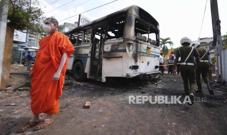 Seorang biksu Buddha Sri Lanka, pendukung presiden Gotabaya Rajapaksa, memeriksa puing-puing akibat bentrokan semalam antara pengunjuk rasa dan polisi di dekat kediaman pribadi Presiden Sri Lanka di pinggiran Kolombo, Sri Lanka, Jumat, 1 April 2022. Sri Lanka telah memblokir akses warga ke berbagai platform media sosial pascagelombang demonstrasi.