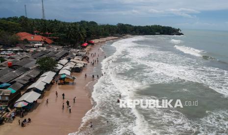 Foto udara wisatawan bermain air di Pantai Sambolo 2, Anyer, Kabupaten Serang Banten, Rabu (25/12/2024). BMKG terimbas efisiensi anggaran 50 persen.