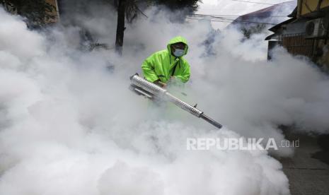  Seorang pekerja yang mengenakan pakaian pelindung berjalan saat dia mendisinfeksi sebuah desa sebagai tindakan pencegahan terhadap penyebaran virus corona di Manila, Filipina pada hari Senin, 15 Maret 2021