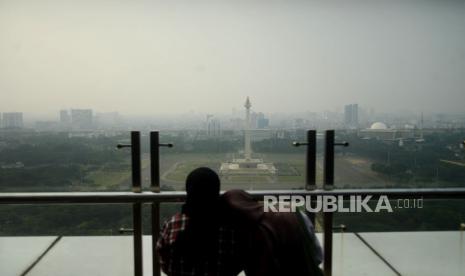 Warga melihat suasana gedung-gedung bertingkat yang tertutup oleh kabut polusi di Jakarta. DLH DKI Jakarta akan melatih petugas uji emisi untuk memperbaiki kualitas udara.