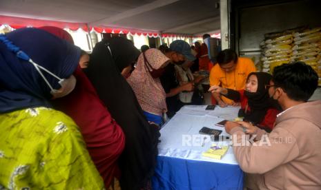 Warga antre membeli sembako saat pasar murah di halaman Disperindag Yogyakarta, Selasa (18/10/2022). Pasar murah ini dalam rangka operasi pasar untuk mengendalikan inflasi di Yogyakarta. Peserta pasar murah diikuti oleh distributor sembako besar seperti Bulog, RNI, dan Alfamidi. Tidak ada batasan berbelanja untuk warga yang akan membeli.