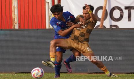 Pesepak bola Arema FC Achmad Maulana (kiri) berebut bola dengan pesebak bola Dewa United Egy Maulana (kanan) pada pertandingan BRI Liga 1 di Stadion Gelora Soeprijadi, Kota Blitar, Jawa Timur, Senin (12/8/2024). Arema FC ditahan imbang oleh Dewa United dengan skor 0-0. 