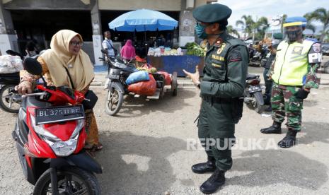 Petugas gabungan dari tim Gugus Tugas Percepatan Penanganan COVID-19 Provinsi Aceh memberikan peringatan kepada pengunjung pasar tradisional untuk memakai masker dan menjalankan protokol kesehatan di Lambaro, Aceh Besar, Aceh, Jumat (14/8/2020). Tim Gugus Tugas Percepatan Penanganan COVID-19 Provinsi Aceh kembali memperketat pengawasan terhadap pelaksanaan protokol kesehatan di tempat umum guna mencegah penularan dan penyebaran COVID-19. 