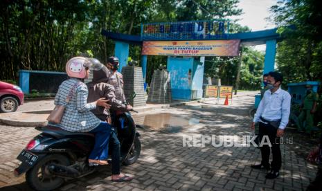 Sejumlah petugas gabungan mencegah wisatawan yang hendak masuk di Pantai Bagedur, Lebak, Banten, Ahad (27/12/2020). Pemkab Lebak menutup sementara seluruh objek wisata di Lebak hingga 4 Januari 2021 untuk menghindari kerumunan wisatawan pada libur Natal dan Tahun Baru 2021 sebagai optimalisasi pencegahan penyebaran COVID-19. 