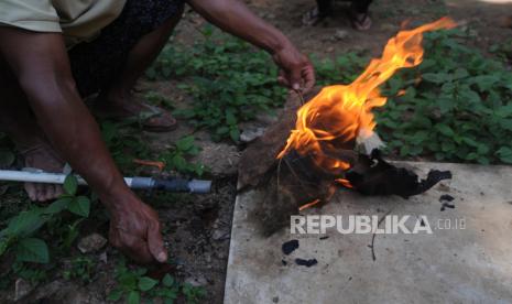 Seorang warga menyalakan api dari saluran gas digester limbah tahu di Gilingan Lor, Urutsewu, Ampel, Boyolali, Jawa Tengah, Kamis (2/9/2021). Warga setempat yang memiliki usaha produsen tahu tersebut memanfaatkan limbah tahu dijadikan energi gas mandiri untuk kebutuhan bahan bakar kompor gas, alat pemanas air dan bahan bakar gas diesel listrik sehingga dapat mengurangi beban biaya. 