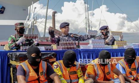 Komandan Gugus Keamanan Laut (Guskamla) Komando Armada (Koarmada) I Laksamana Pertama TNI Yayan Sofiyan (tengah) didampingi Komandan Lanal Batam Kolonel Laut (P) Sumantri (kiri) dan Komandan KRI Alamang-644 Letkol Laut Mohamand Fuad hasan (kanan) menunjukan barang bukti rokok saat rilis penangkapan penyelundupan rokok ilegal di Dermaga Pangkalan TNI AL (Lanal) Batam, Kepulauan Riau, Minggu (28/3/2021). Patroli keamanan laut TNI Angkatan Laut KRI Alamang-644 berhasil mengamankan kapal beserta delapan orang ABK yang menyelundupkan rokok ilegal sebanyak 1673 karton berbagai jenis rokok dari Jurong, Singapura. 