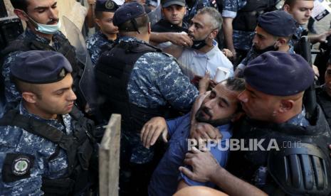 Pelanggan bentrok dengan polisi anti huru hara ketika mereka mencoba menyerbu sebuah bank di Beirut, Lebanon, Rabu, 6 Oktober 2021. Puluhan warga Lebanon berkumpul di luar sebuah bank di pusat kota Beirut menuntut agar mereka diizinkan untuk menarik simpanan mereka yang telah diblokir di tengah krisis Lebanon. krisis keuangan dan ekonomi yang parah.