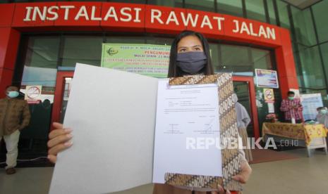 Seorang pasien positif yang telah sembuh dari COVID-19 menunjukkan surat keterangan pemeriksaan COVID-19 di RSUD Anshari Shaleh Banjarmasin, Kalimantan Selatan, Kamis (25/6). 