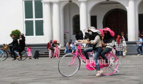 Warga mengendarai sepeda di Taman Kota Tua di Jakarta, Indonesia, 01 Juni 2022. Kementerian Kesehatan Indonesia memantau perkembangan kasus baru COVID-19 setelah pelonggaran mandat masker luar ruangan.