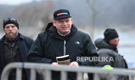 Pemimpin partai politik sayap kanan Denmark Stram Kurs, Rasmus Paludan, memegang salinan Alquran sambil diawasi oleh polisi saat dia melakukan protes di luar kedutaan Turki di Stockholm, Swedia, 21 Januari 2023. Rasmus Paludan Berulah Lagi, Kini Bakar Alquran di Depan Masjid Denmark