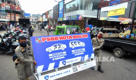 Anggota Satpol PP Kota Bogor membawa papan informasi dalam razia operasi kepatuhan Pembatasan Sosial Berskala Besar (PSBB) di jalan Suryakencana, Kota Bogor, Jawa Barat, Minggu (3/5/2020). Gubernur Jawa Barat Ridwan Kamil mengatakan akan memberlakukan PSBB secara menyeluruh di 27 Kabupaten dan Kota se-Jawa Barat mulai tanggal 6 Mei 2020 sebagai upaya menekan angka penyebaran virus Corona (COVID-19) di wilayah Jawa Barat