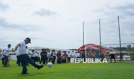 Kepala Otorita Ibu Kota Nusantara (OIKN) Basuki Hadimuljono (kiri) menendang bola saat mengunjungi pembangunan Training Center PSSI pada kegiatan Nusantara International Partner Visit (NIPV) di Ibu Kota Nusantara (IKN), Penajam Paser Utara, Kalimantan Timur, Jumat (14/2/2025). Pembangunan Training Center PSSI tahap pertama telah selesai dan akan dilanjutkan untuk pembangunan tahap kedua yang mencakup pembangunan lapangan latihan tambahan, lapangan futsal, mini stadion, kolam renang, serta lapangan dalam ruangan (indoor). 