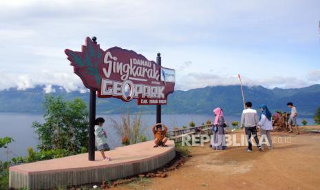 Sejumlah pengunjung menikmati panorama Danau Singkarak dari objek wisata puncak Aur Sarumpun, Kabupaten Tanah Datar, Sumatera Barat, Sabtu (19/12/2020). Puncak Aur Sarumpun merupakan objek wisata alam yang dikelola masyarakat setempat yang menawarkan nuansa ketinggian dan panorama 360 derajat termasuk Danau Singkarak.