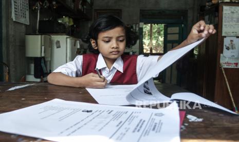 Siswa sekolah dasar mengerjakan soal ujian akhir semester di rumahnya di Bangunjiwo, Kasihan, Bantul, DI Yogyakarta, Selasa (8/6/2021). Gubernur Yogyakarta Sri Sultan HB X menyatakan sekolah tatap muka di wilayahnya dibuka setelah vaksinasi Covid-19 terhadap guru dan tenaga kependidikan selesai dilakukan. 