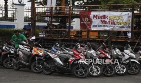 Petugas menurunkan sepeda motor pemudik dari truk angkutan kendaraan pada Program Mudik Gratis Lebaran 2022 di Terminal Tirtonadi, Kota Solo, Jawa Tengah, Kamis (28/4/2022).