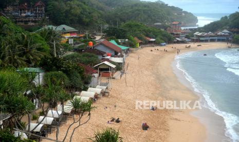 Wisatawan menghabiskan sore hari di Pantai Pulang Sawal, Gunungkidul, Yogyakarta, Selasa (1/11/2022). Pantai Pulang Sawal atau juga dikenal Pantai Indrayanti menjadi salah satu destinasi wisata pantai favorit wisatawan. Pantai yang terletak di Timur Pantai Baron ini menjadi favorit wisatawan karena berpasir putih dan restoran berada di tepi pantai. Selain itu, di sekitar pantai juga sudah banyak terdapat penginapan bagi wisatawan.